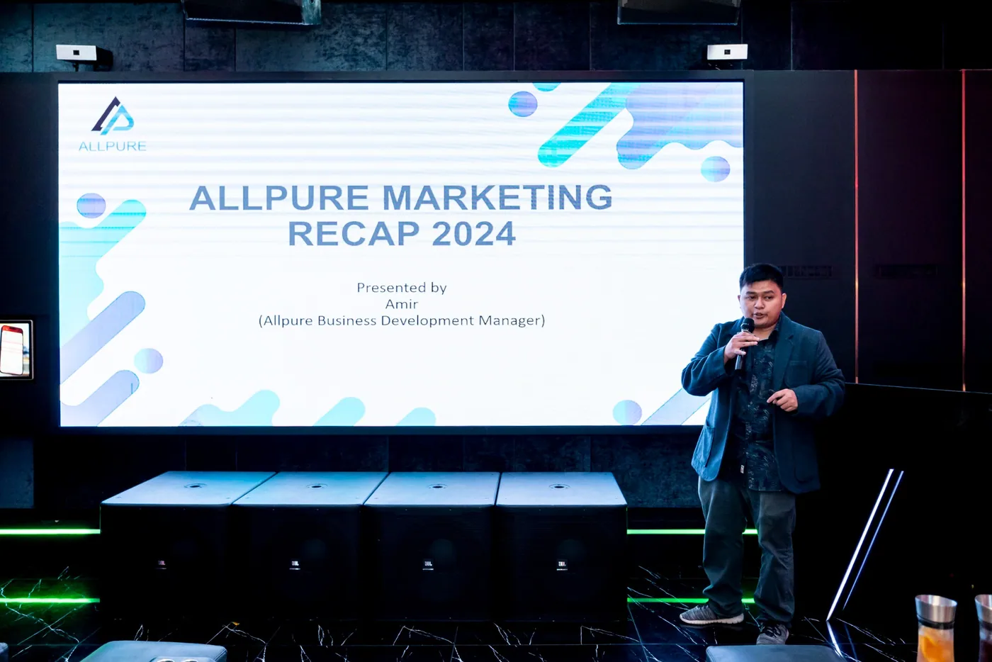 Amir delivering a business and marketing recap presentation at an Allpure event